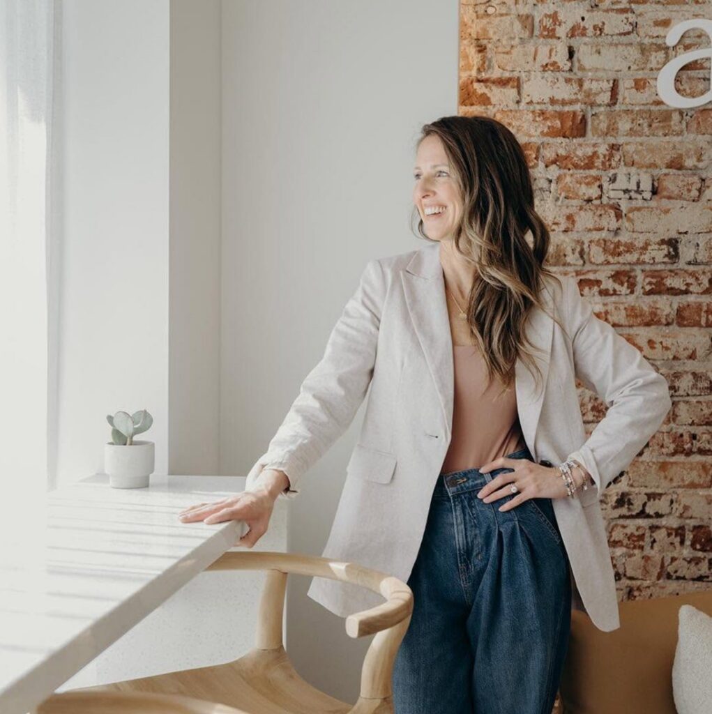 Dr. Amanda Vanderstelt, board-certified orthodontist, smiling by the window inside Aligned Orthodontics in Platt Park