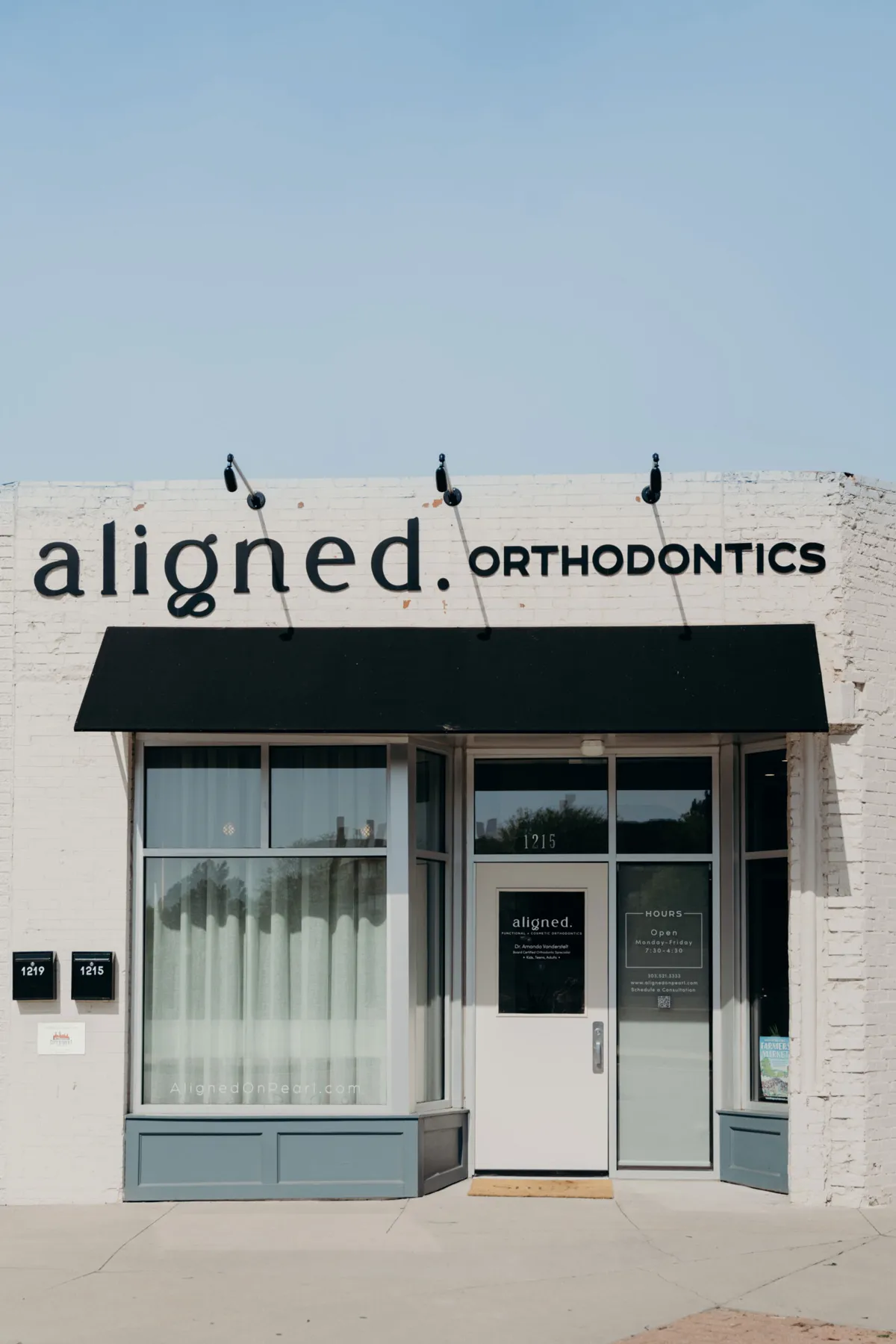 The aligned. Orthodontics storefront at 1215 S Pearl St in Denver, white brick with a black awning